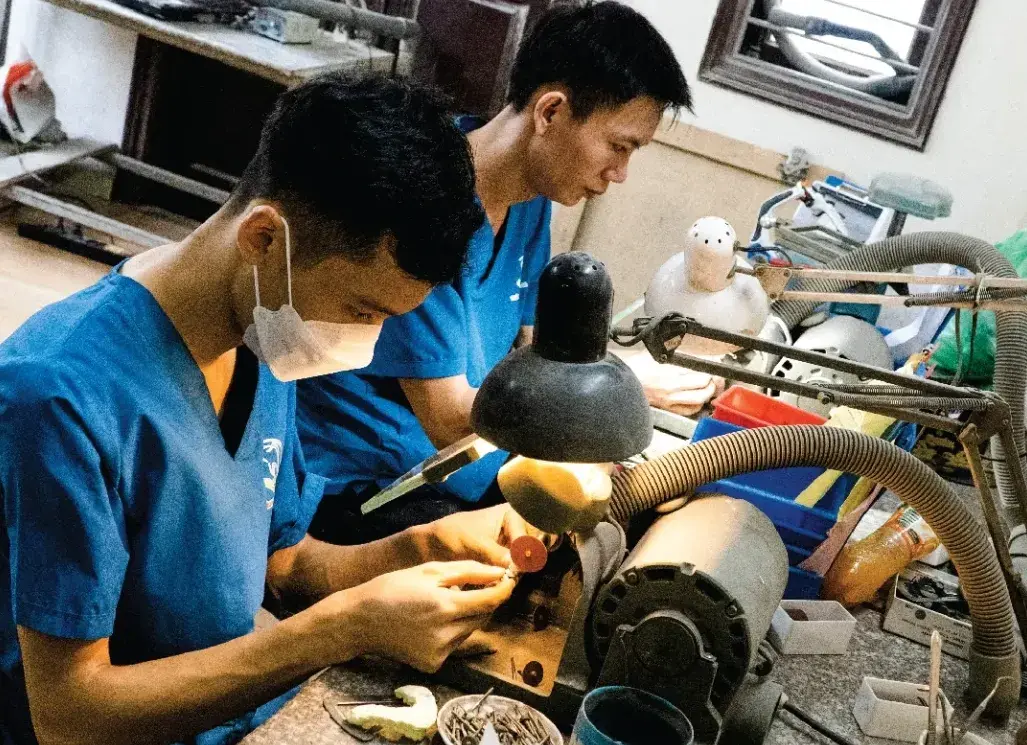 Kỹ thuật viên Thành Lợi mài chỉnh phục hình tại bàn